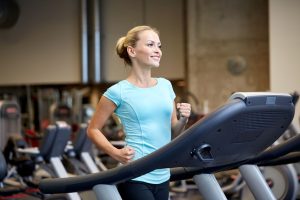 Comment optimiser ta récupération sportive quand les étirements ne suffisent plus ? smiling woman exercising on treadmill in gym